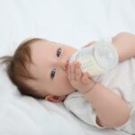 bebé bebiendo leche de un biberón